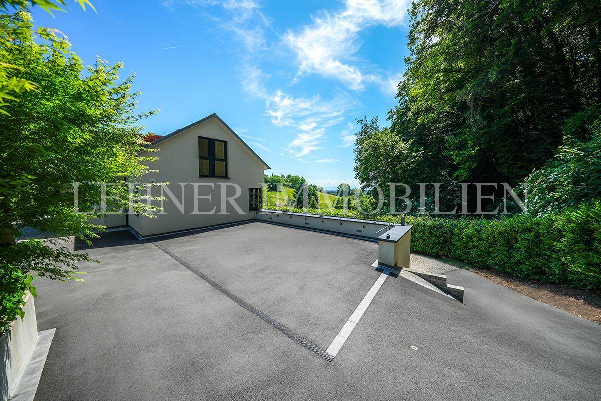 Weitläufige Auffahrt zum Haus mit Blick auf die umliegende grüne Landschaft.