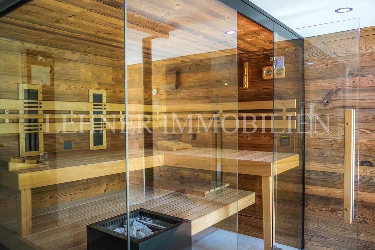 Gemütliche Holzsauna mit mehreren Bänken und traditionellem Saunaofen.