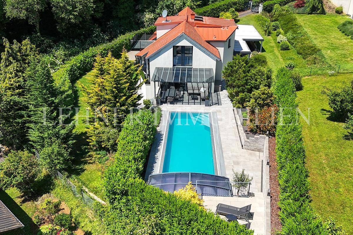Luftaufnahme des Anwesens mit großem Swimmingpool, Wintergarten und gepflegtem Gartenbereich.