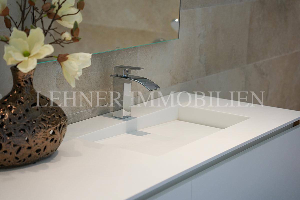 Nahaufnahme eines modernen Waschbeckens mit elegantem Wasserhahn im Badezimmer.