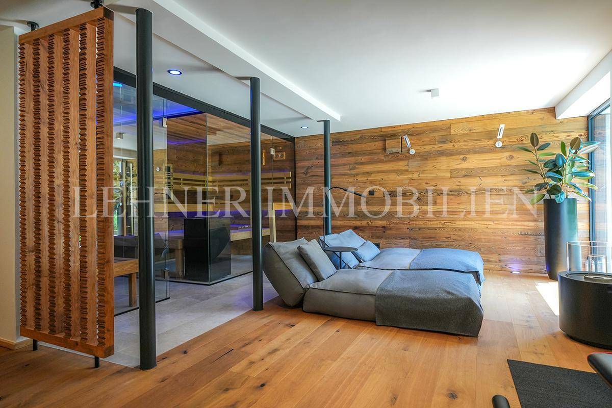 Stilvoller Wellnessbereich mit Liegemöglichkeiten, Holzwand und moderner Sauna.