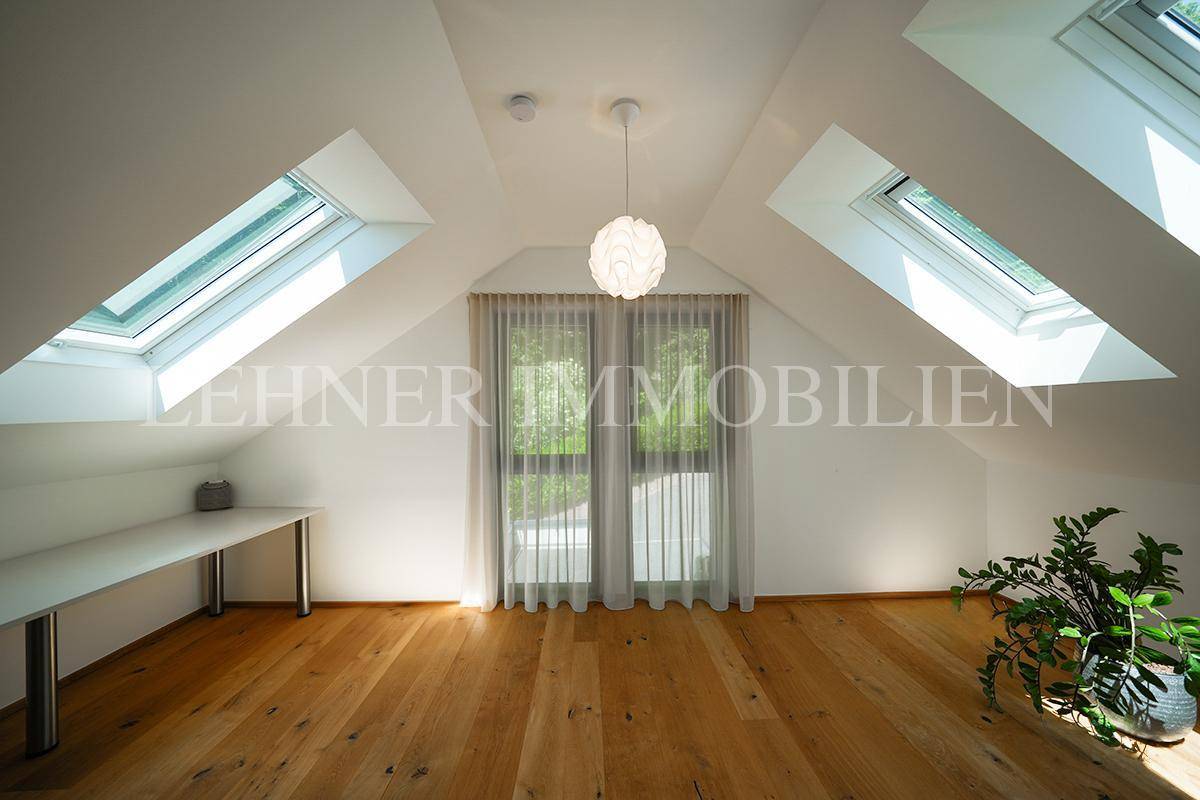 Helles Zimmer mit Holzboden, Dachschrägen und großen Dachfenstern, ideal als Arbeits- oder Gästezimmer.