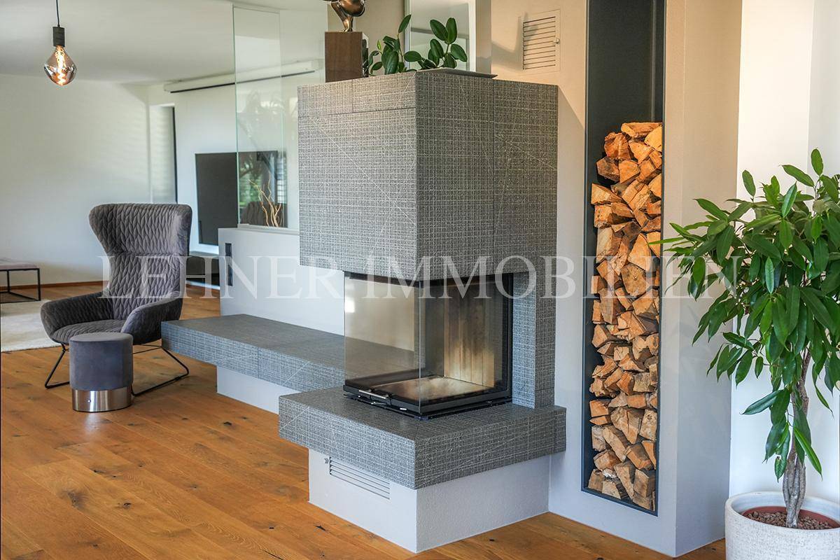 Moderner Kamin mit integriertem Holzregal, ein stilvolles Element im Wohnzimmer.