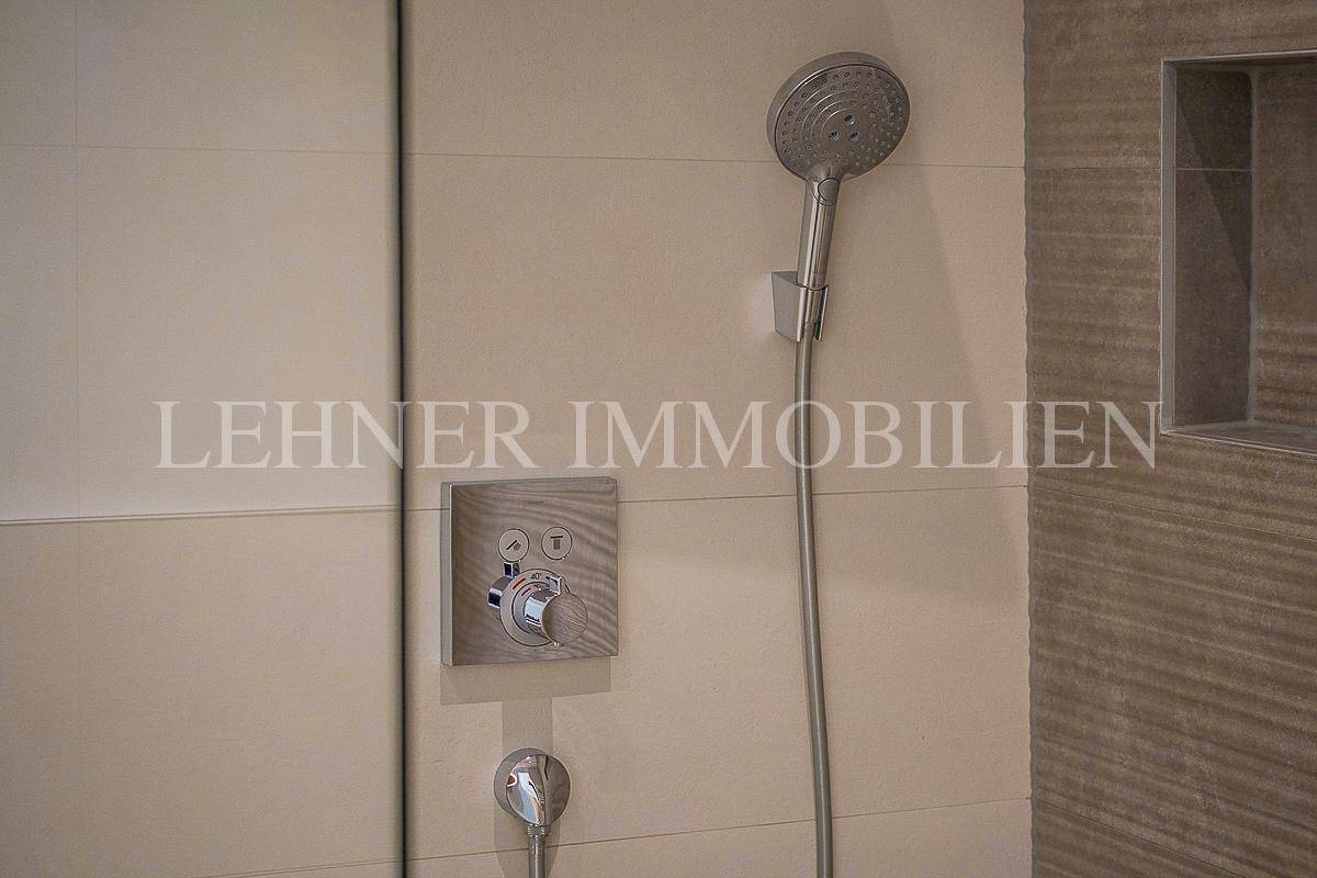 Duscharmatur und Handbrause in der begehbaren Dusche, mit modernen Fliesen und Nische.