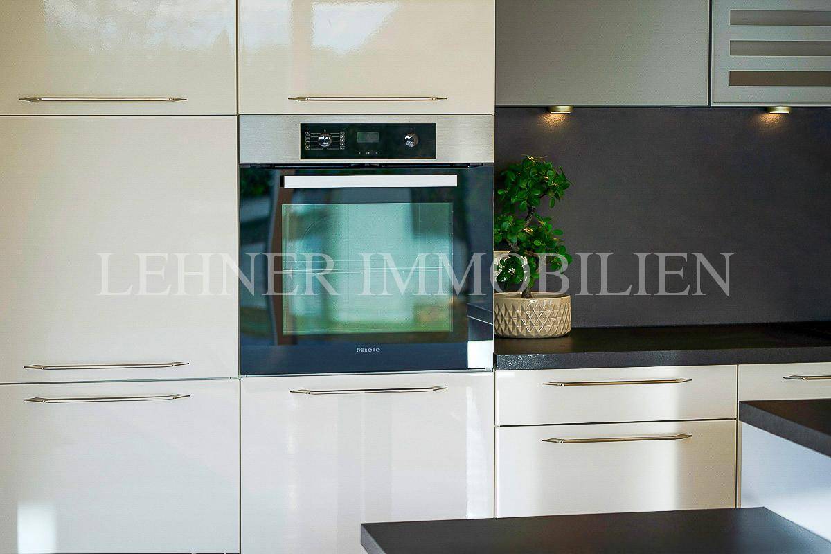 Integrierter Backofen der Marke Miele in der modernen Einbauküche mit glänzenden Fronten.