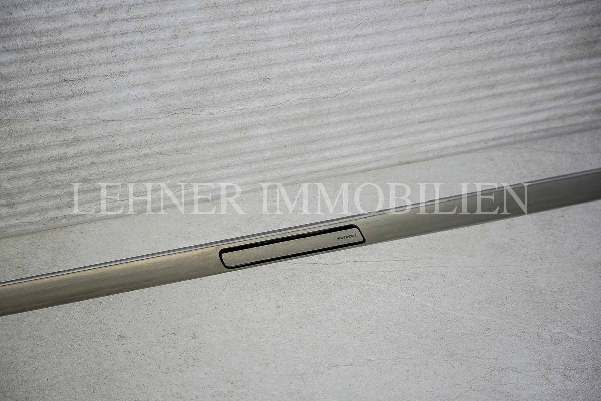 Nahaufnahme des eleganten, linearen Duschabflusses im modernen Badezimmer.