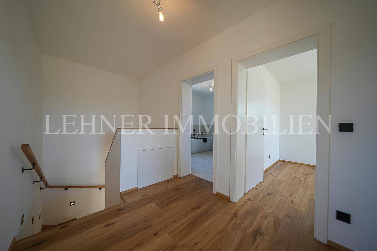 Geräumiger Flur mit Holzboden, der den Blick auf angrenzende Räume freigibt.