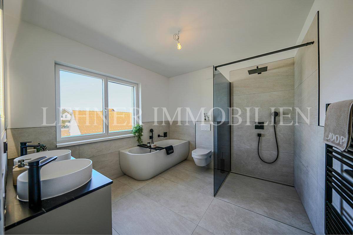 Modernes Badezimmer mit freistehender Badewanne, großer Dusche und Doppelwaschbecken.