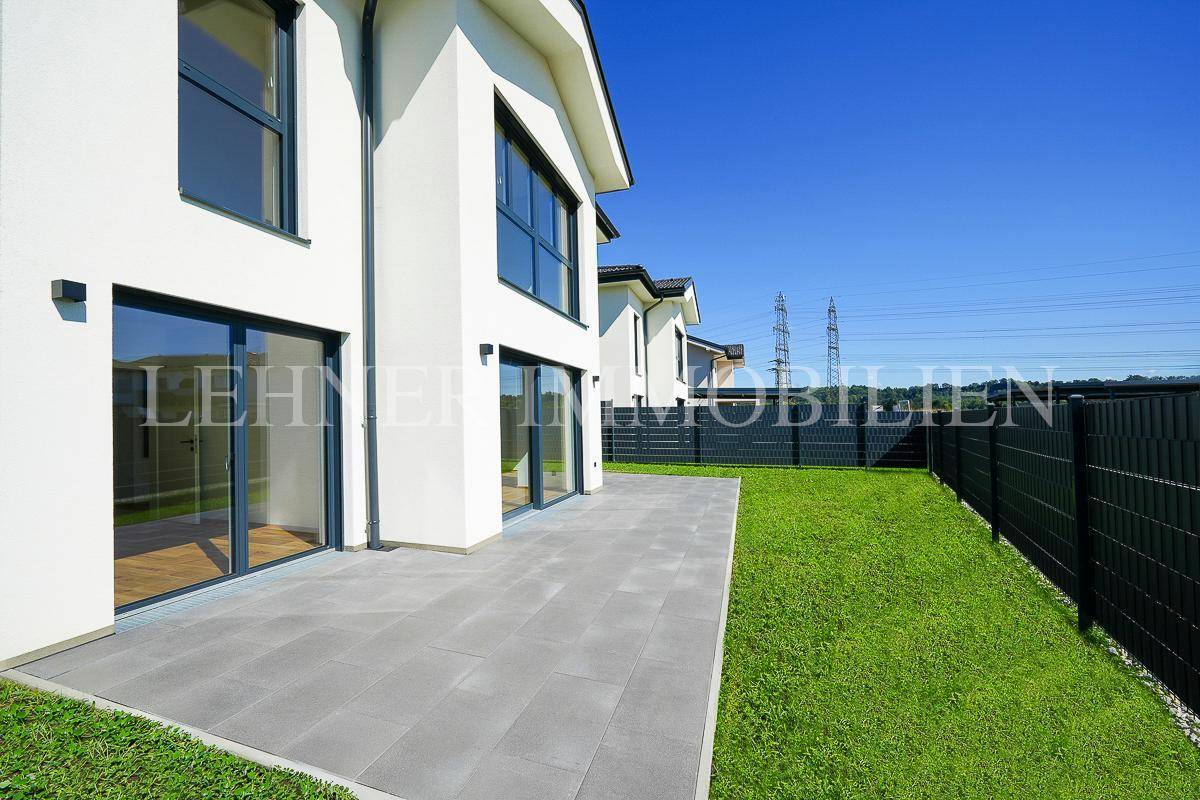 Geräumige Terrasse mit Blick auf den Garten und die umliegende Landschaft, ideal für entspannte Momente.