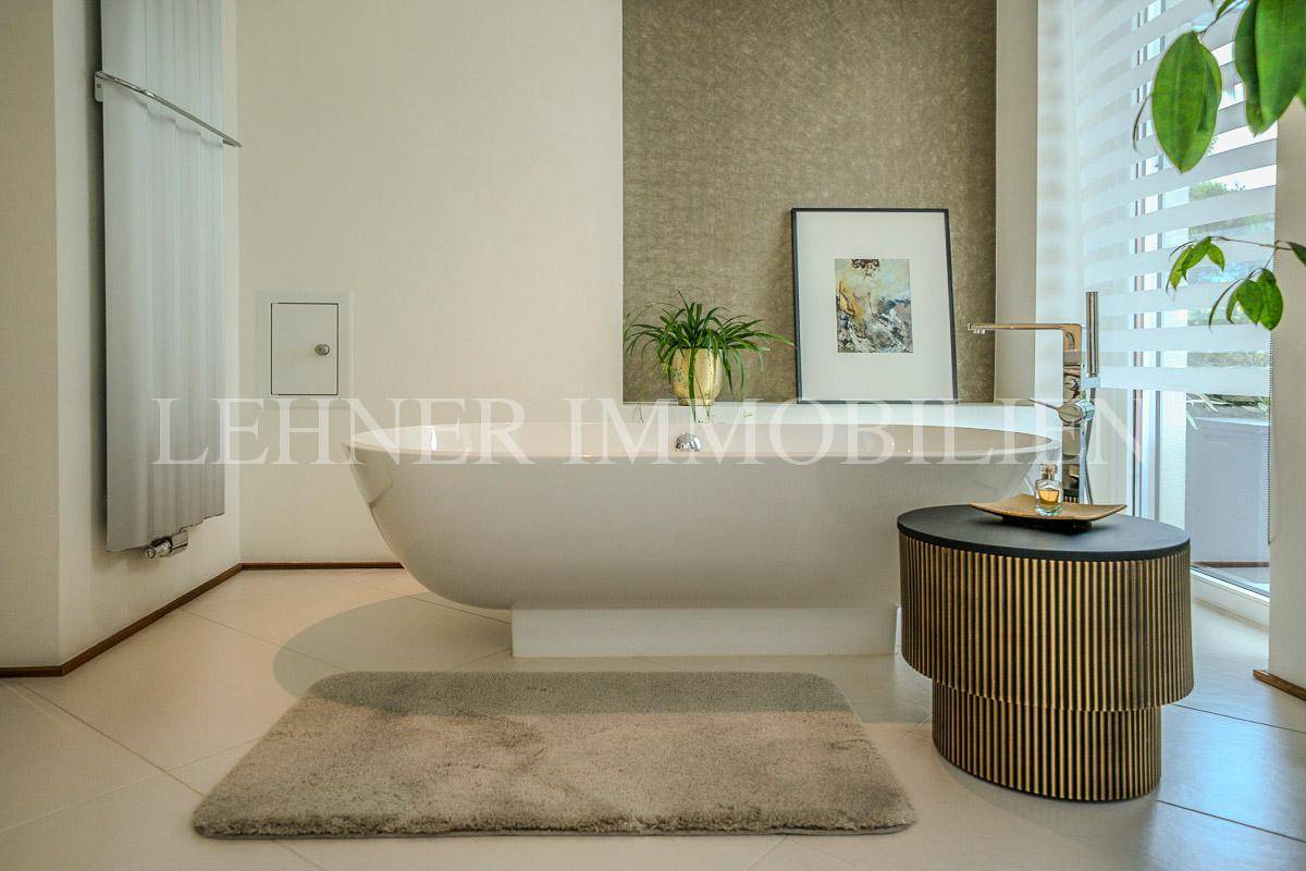 Freistehende Badewanne in einem hellen Badezimmer mit modernem Heizkörper.
