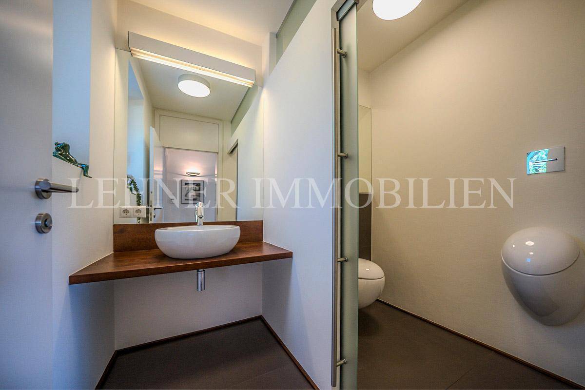 Modernes Gäste-WC mit Waschbecken, wandhängendem WC und Urinal.