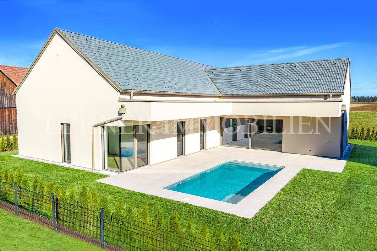 Luftaufnahme des modernen Einfamilienhauses mit Pool, weitläufigem Garten und angrenzender Natur.
