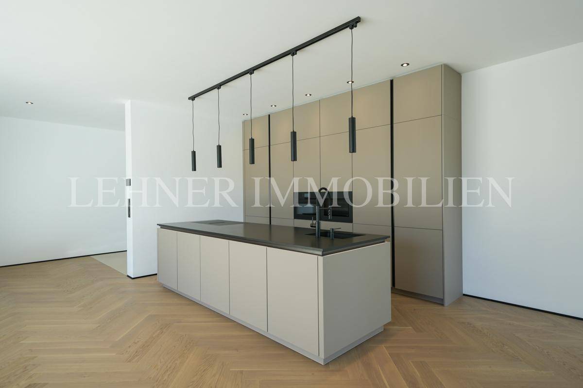 Moderne Einbauküche mit integrierten Geräten, Kücheninsel und eleganten Hängeschränken.