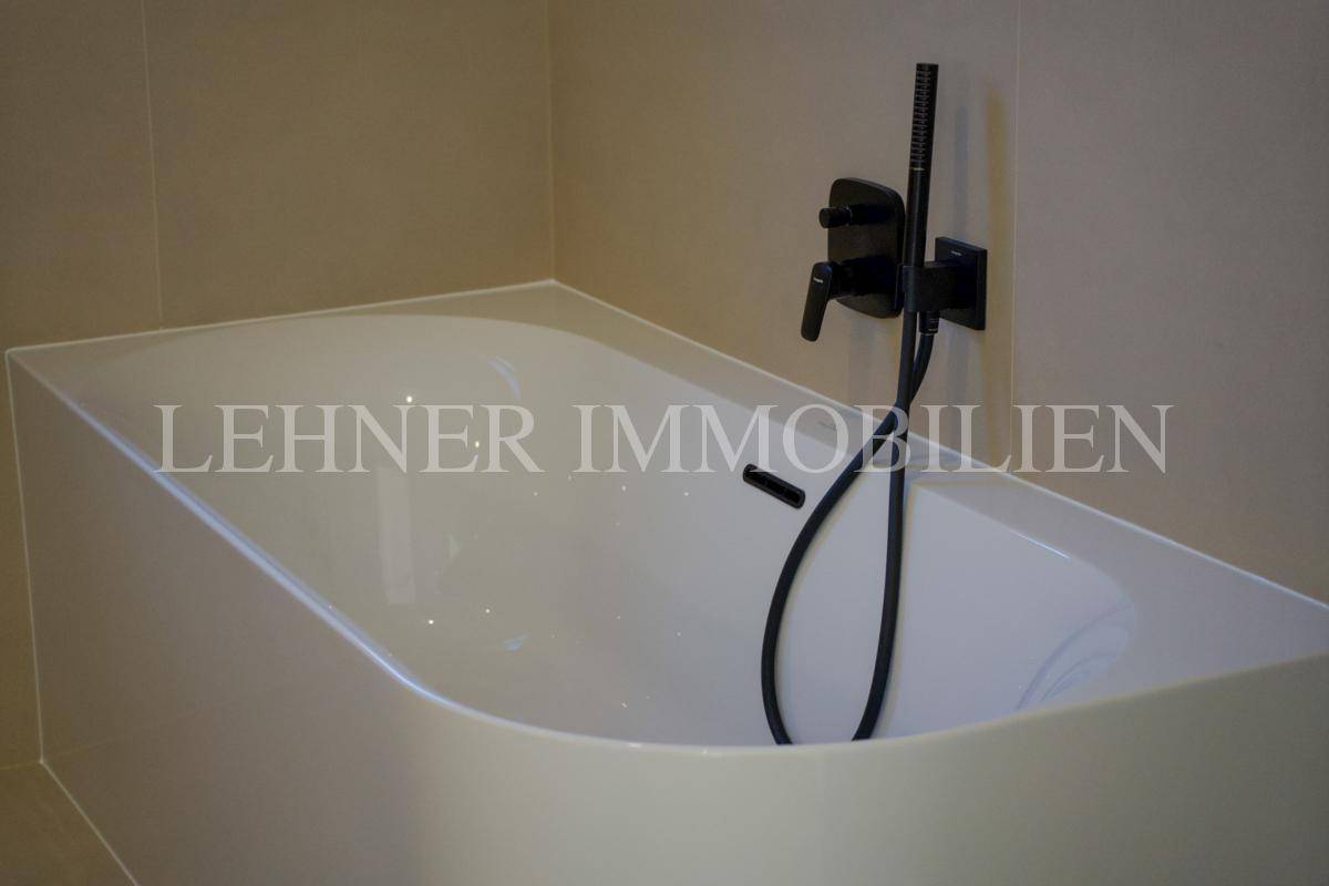 Detailansicht der modernen Badewanne mit eleganten schwarzen Armaturen im Badezimmer.