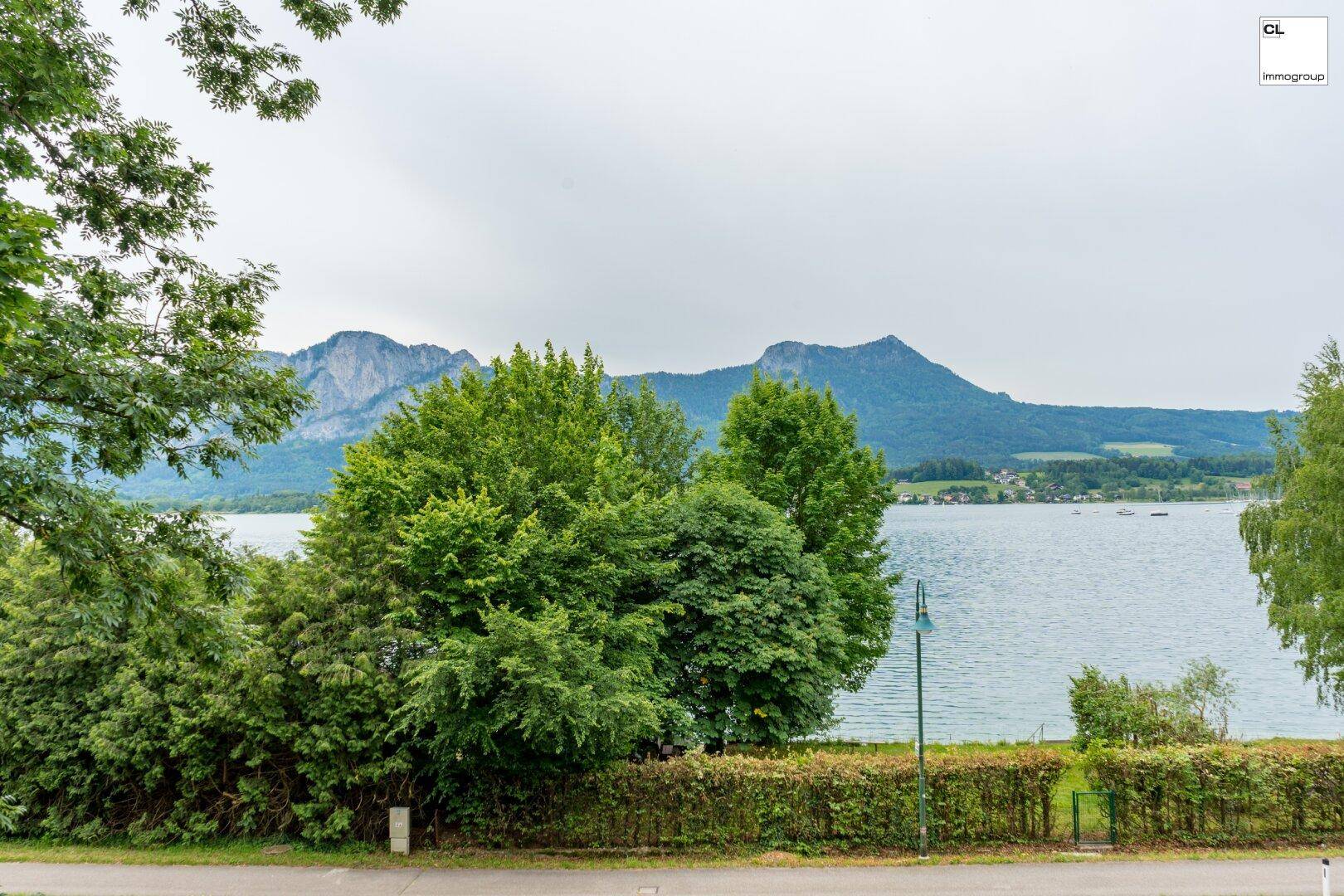 Panoramablick auf den See und die majestätischen Berge, umgeben von üppigem Grün.
