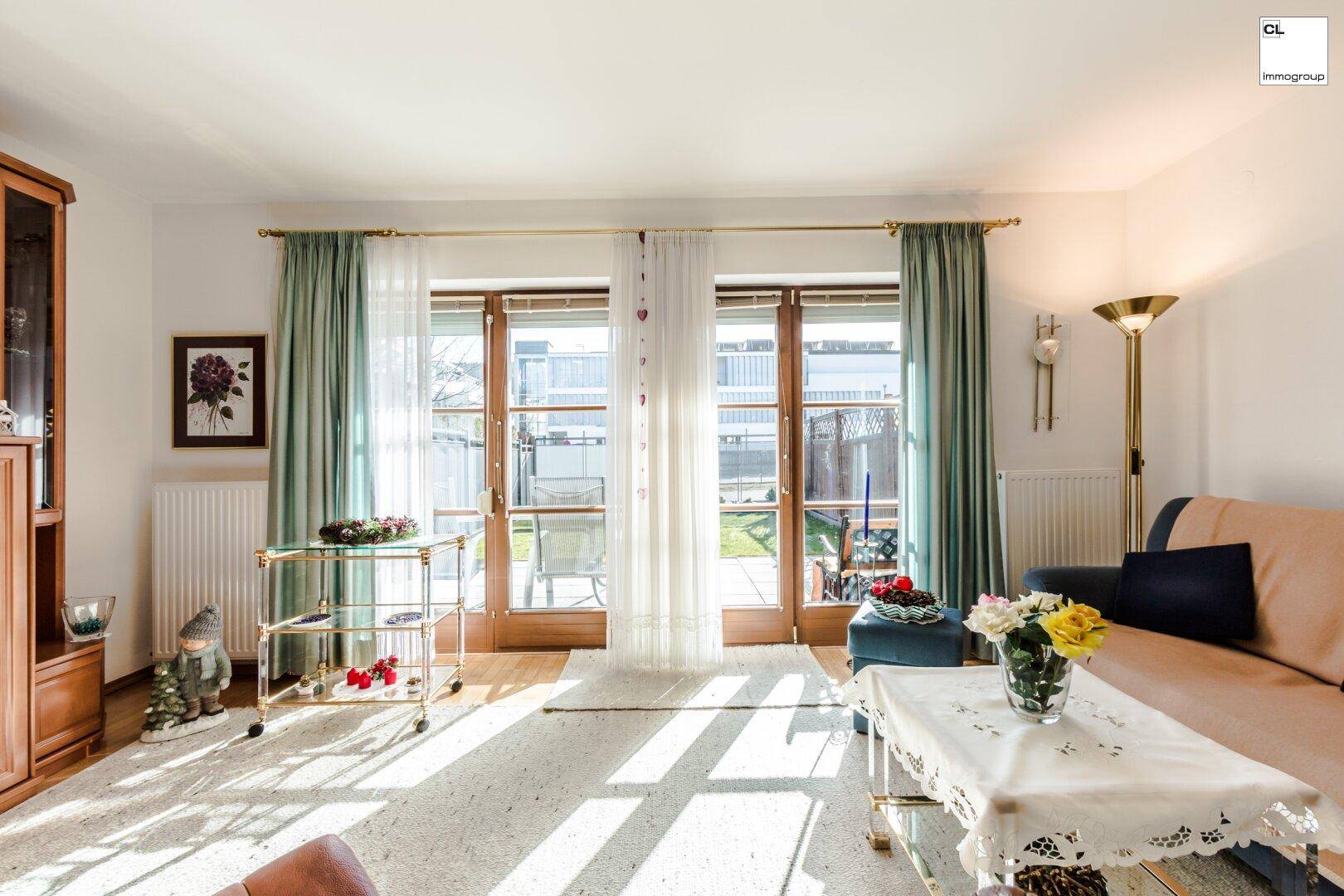 Helles Wohnzimmer mit Zugang zur Terrasse mit Garten