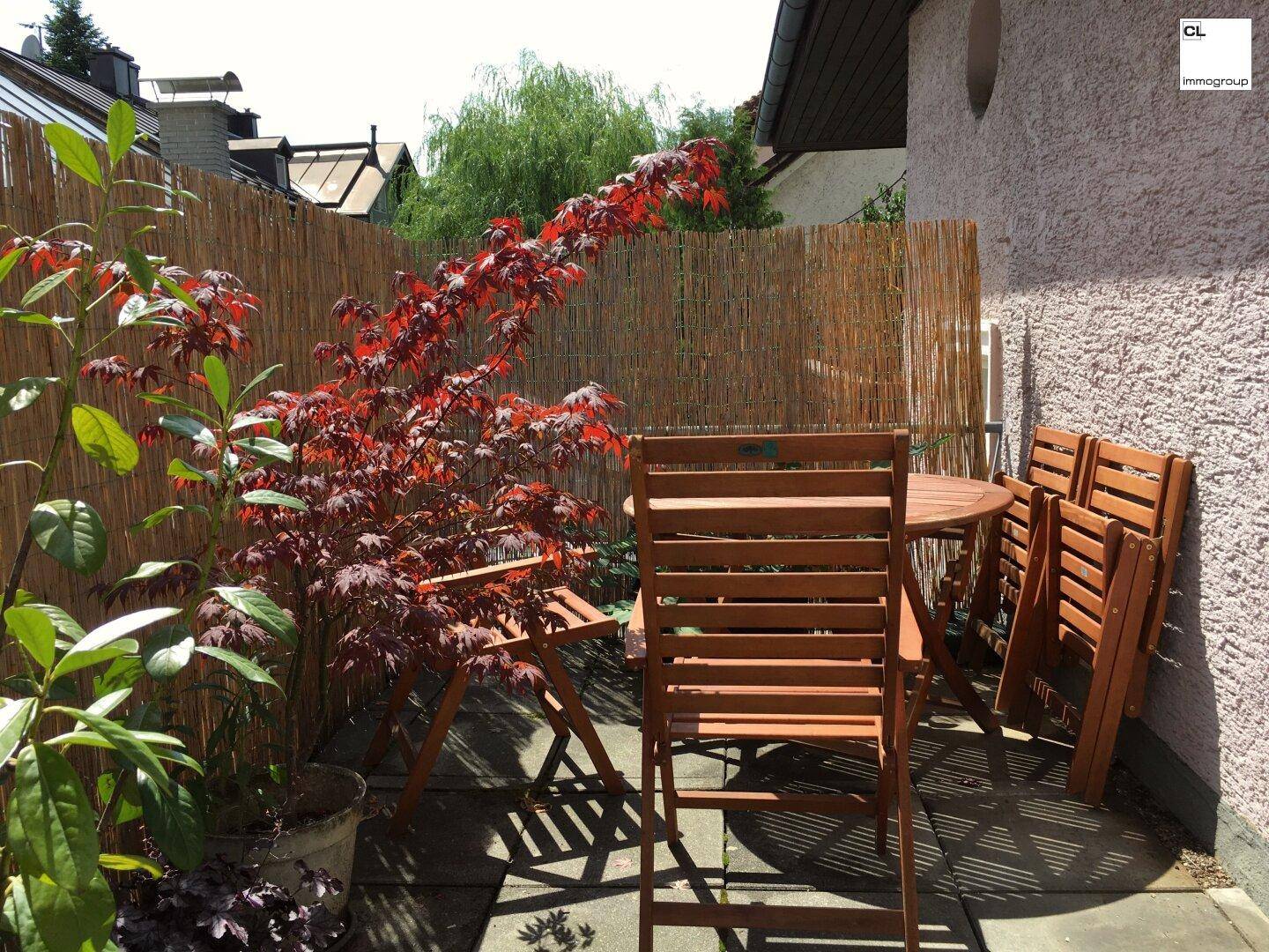 Gemütlicher kleiner Gartenbereich mit Holzzaun und Sitzgelegenheiten für entspannte Stunden.