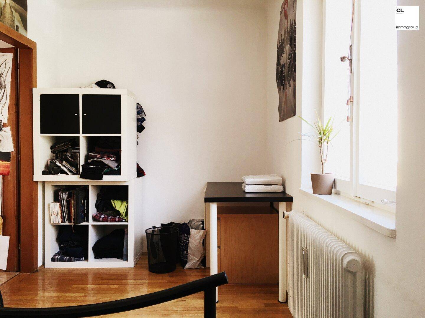 Kleiner Raum mit Laminatboden, Fenster und Stauraum, nutzbar als Schlaf- oder Arbeitszimmer.