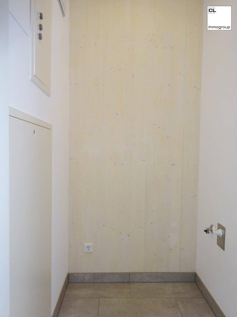 Praktischer Hauswirtschaftsraum mit Fliesenboden und Anschlüssen für Waschmaschine.