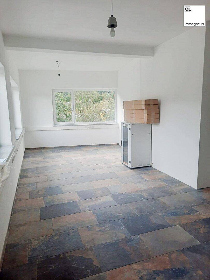 Geräumiger Büroraum mit großen Fenstern und modernen Fliesenböden, bereit zur individuellen Einrichtung.
