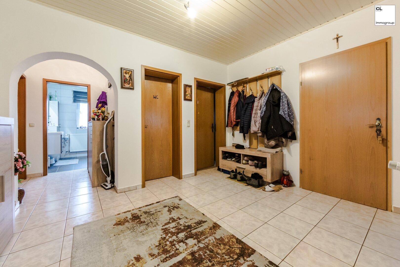 Geräumiger Flur mit Fliesenboden, Garderobe und Zugang zu weiteren Zimmern.