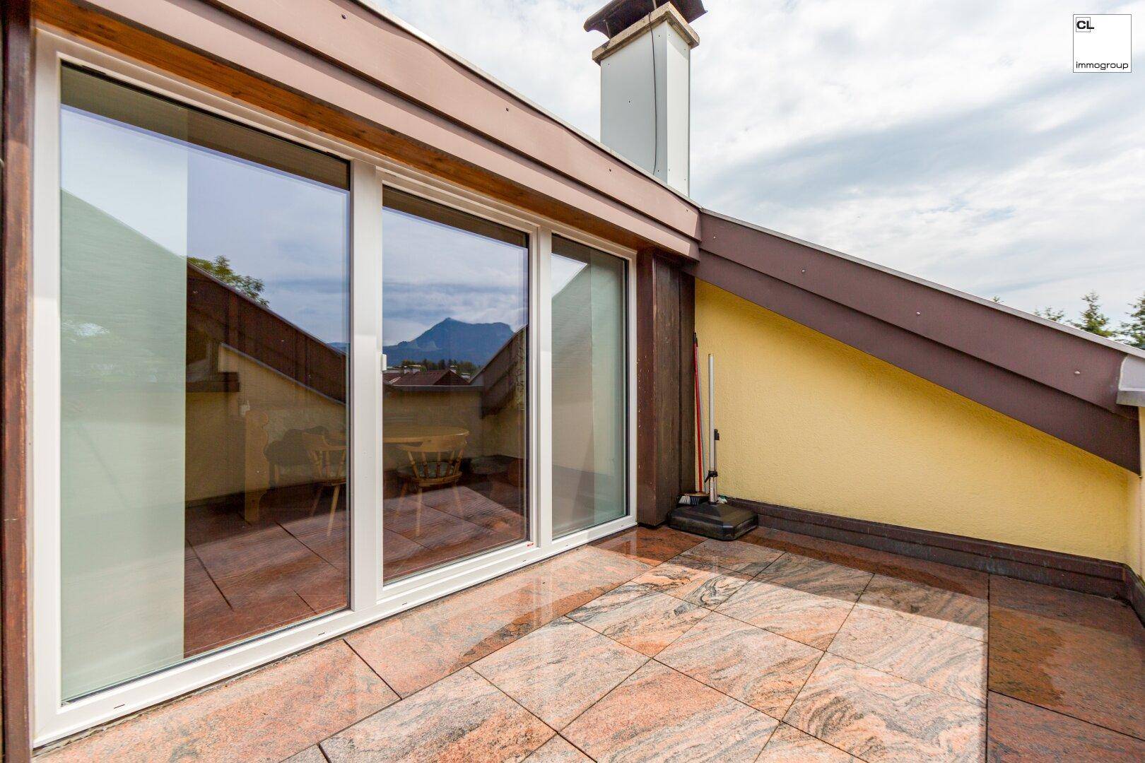 Geräumige Dachterrasse mit Fliesenboden und weitem Bergblick, ideal zum Entspannen.