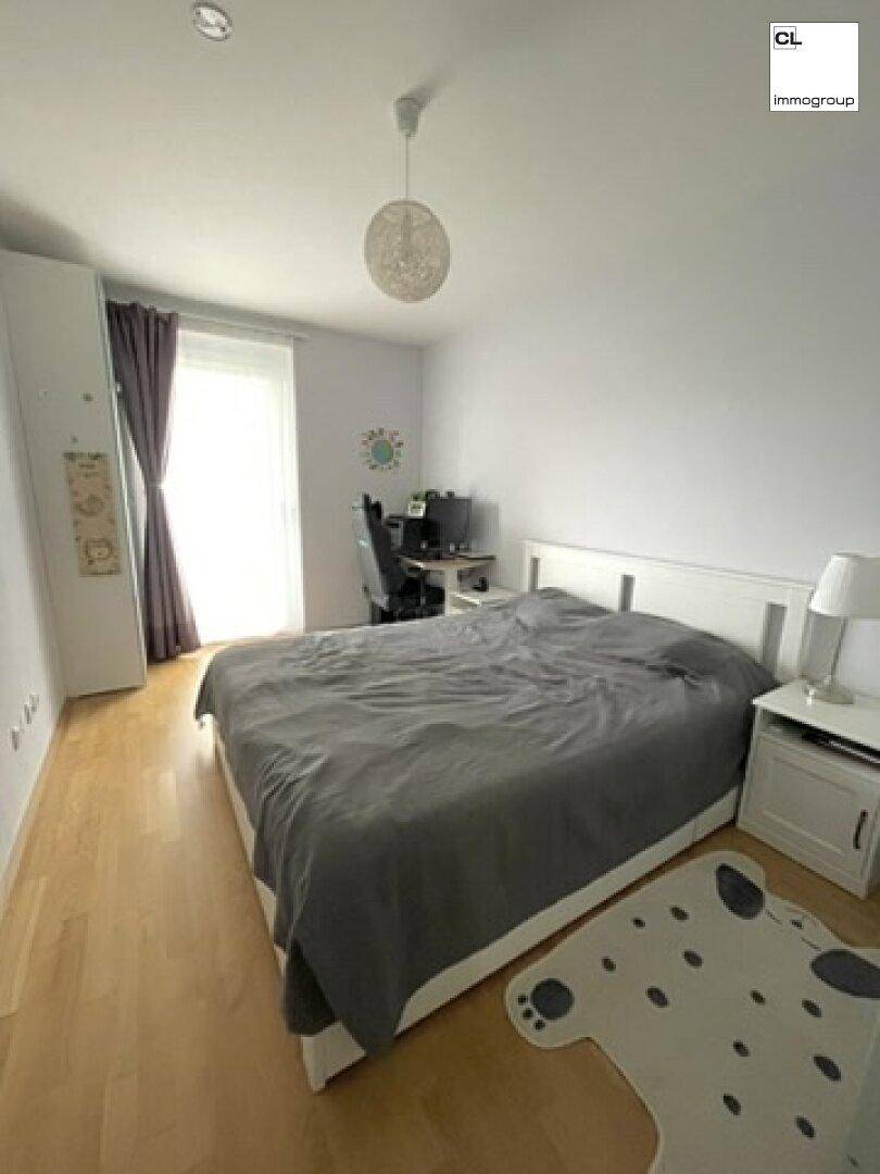 Helles Schlafzimmer mit Doppelbett, Schreibtisch und Holzboden, ideal zum Entspannen und Arbeiten.