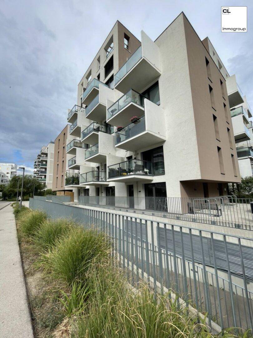 Moderne Wohnanlage mit mehreren Balkonen und zeitgenössischer Architektur unter bewölktem Himmel.