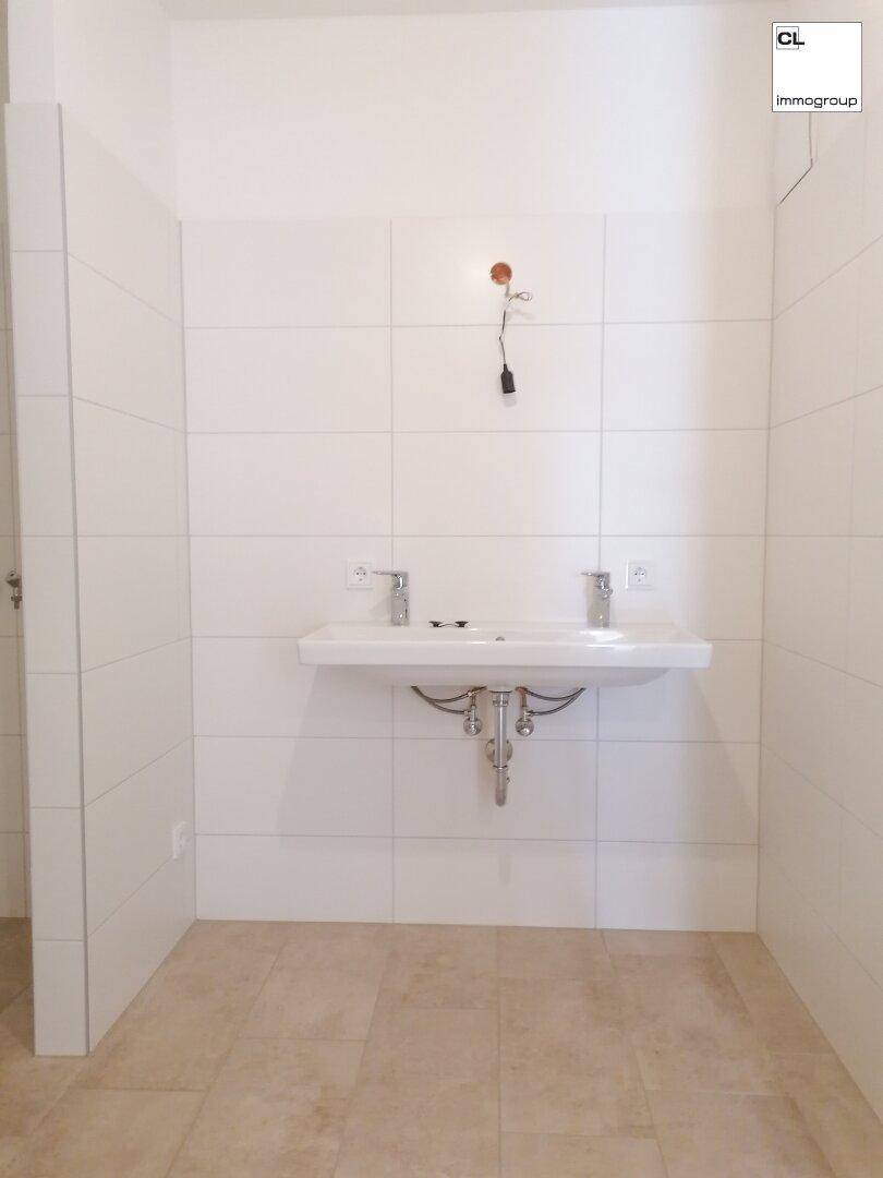 Badezimmer mit modernem Doppelwaschbecken und weißen Fliesen, bietet viel Platz.