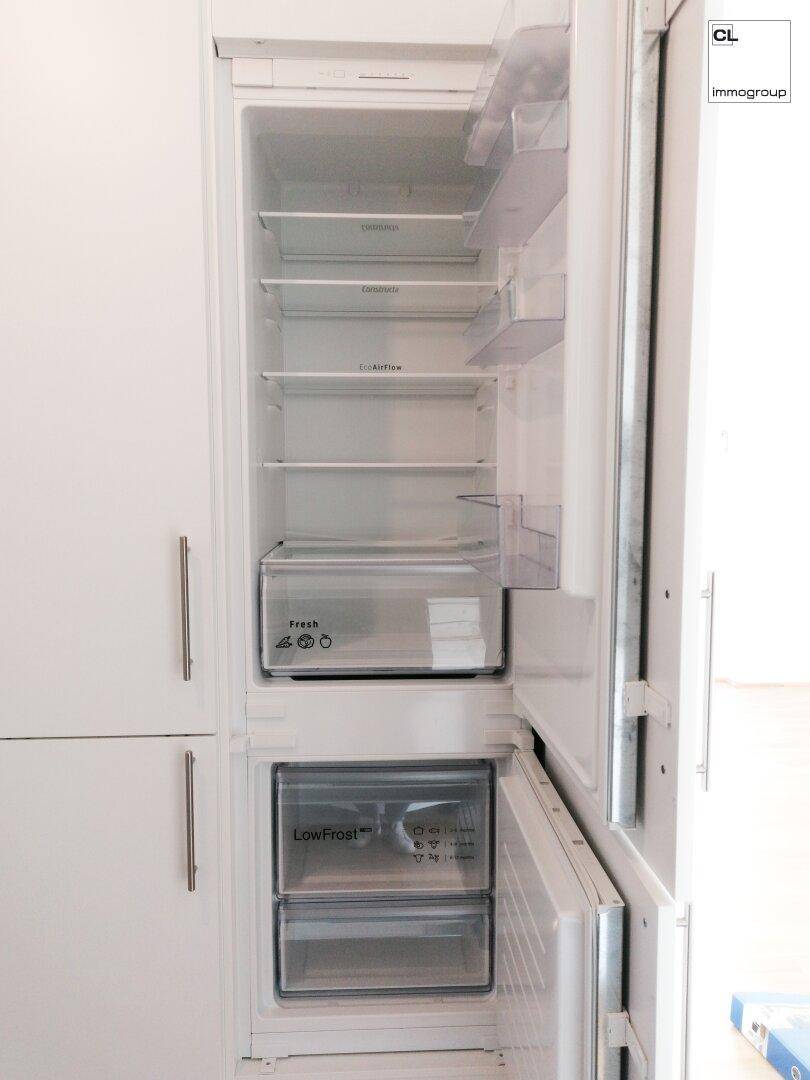Integrierter Kühlschrank mit Gefrierfach und viel Stauraum in einer modernen Küche.