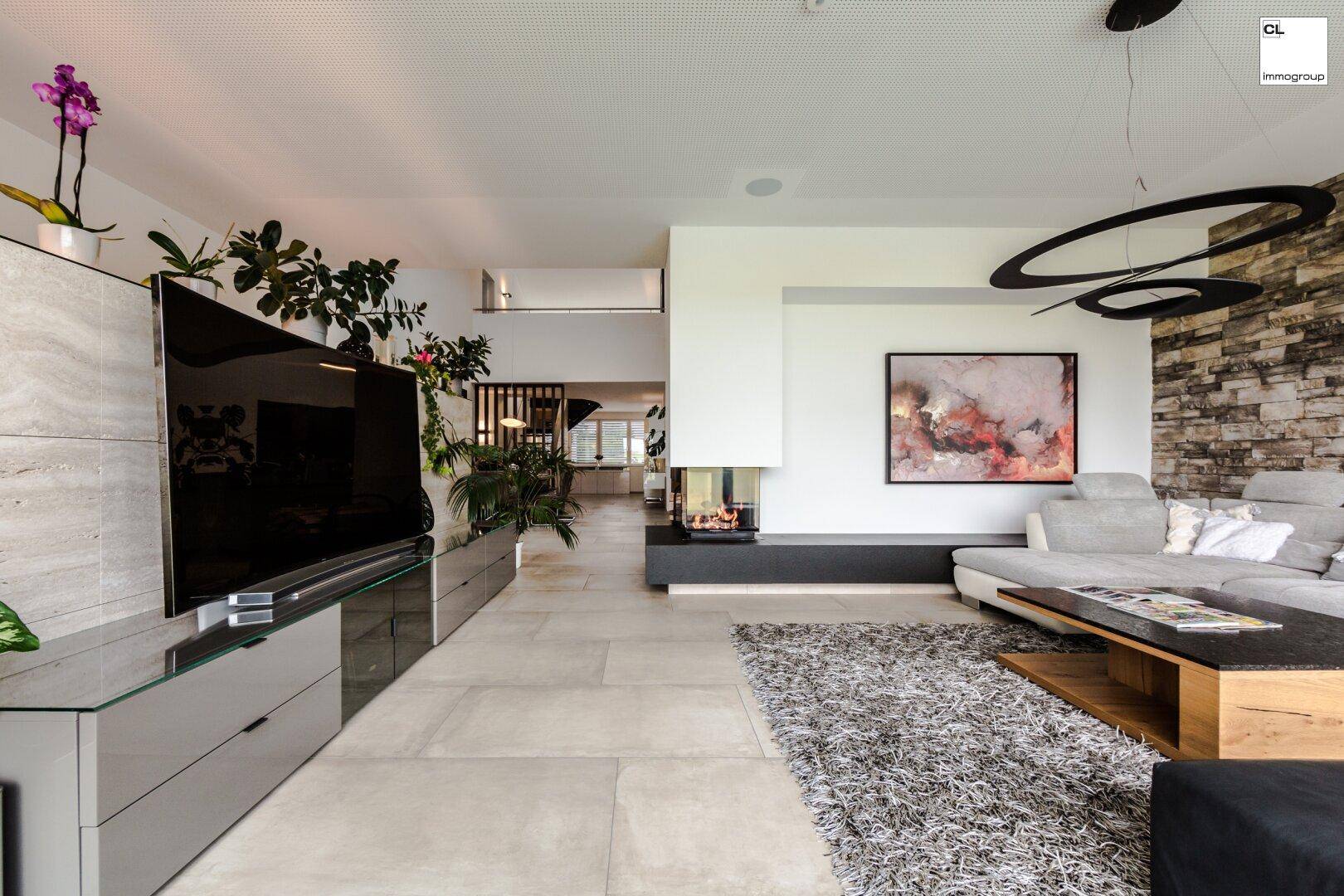 Geräumiges Wohnzimmer mit modernem Kamin, großem Sofa und Steinwandakzent.