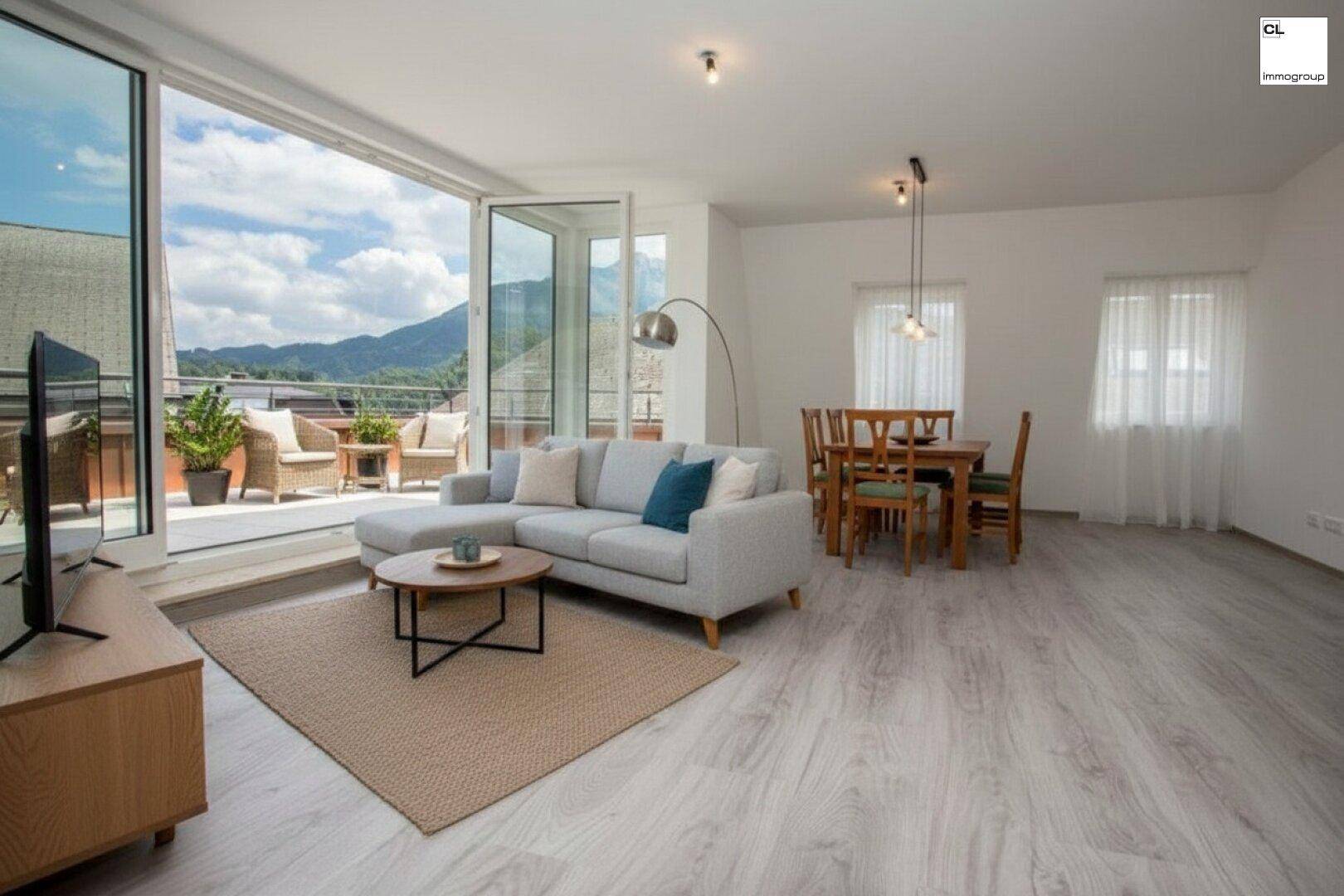 Offener Wohn-Essbereich mit hellem Laminatboden, moderner Einrichtung und Zugang zur Terrasse.