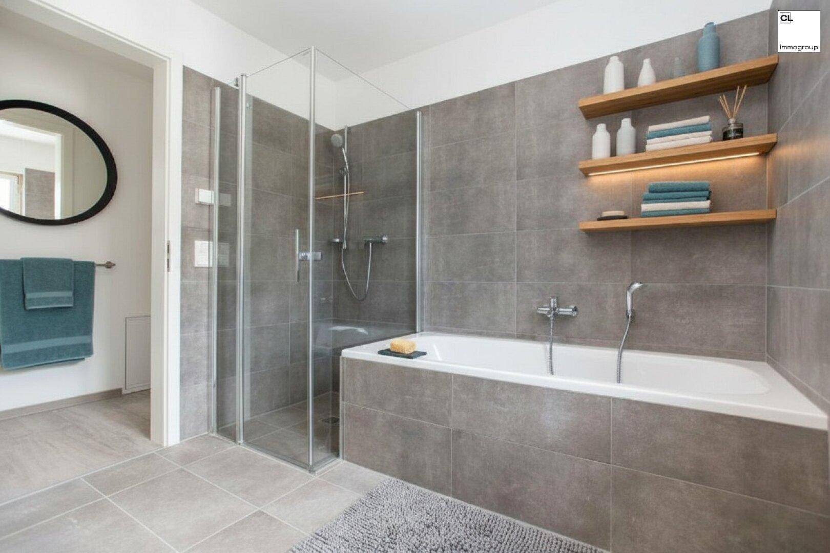 Modernes Badezimmer mit großer Badewanne, begehbarer Dusche und grauen Fliesen.