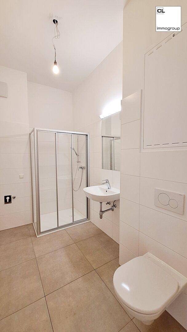 Modernes Badezimmer mit Duschkabine, Waschbecken und wandhängendem WC.