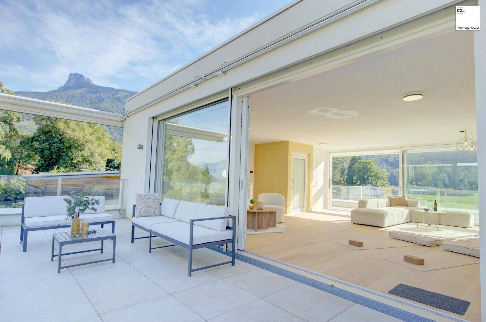 Große Terrasse mit bequemen Outdoor-Möbeln und beeindruckendem Blick auf die umliegende Berglandschaft.