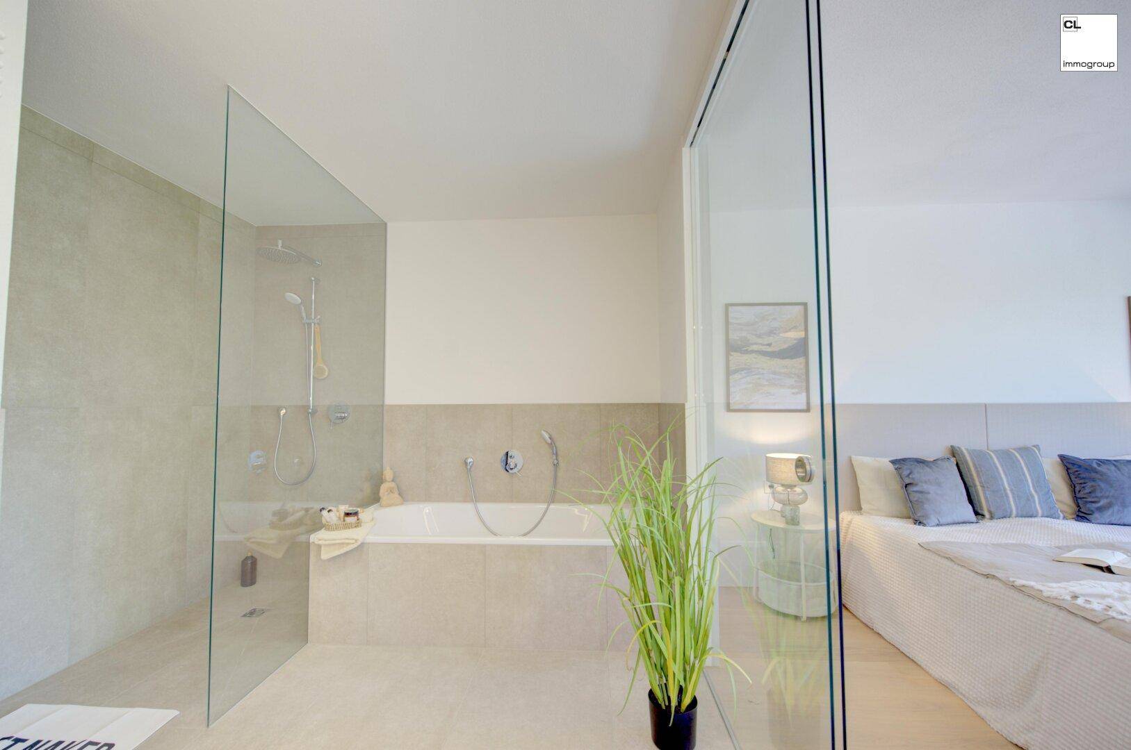 Modernes Badezimmer mit Badewanne und begehbarer Dusche, offen zum Schlafbereich.