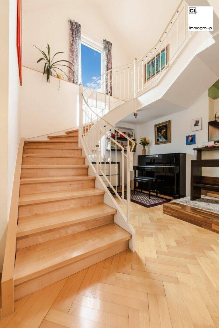 Elegante Holztreppe mit weißem Geländer, die die Etagen verbindet, mit einem Klavier im Hintergrund.