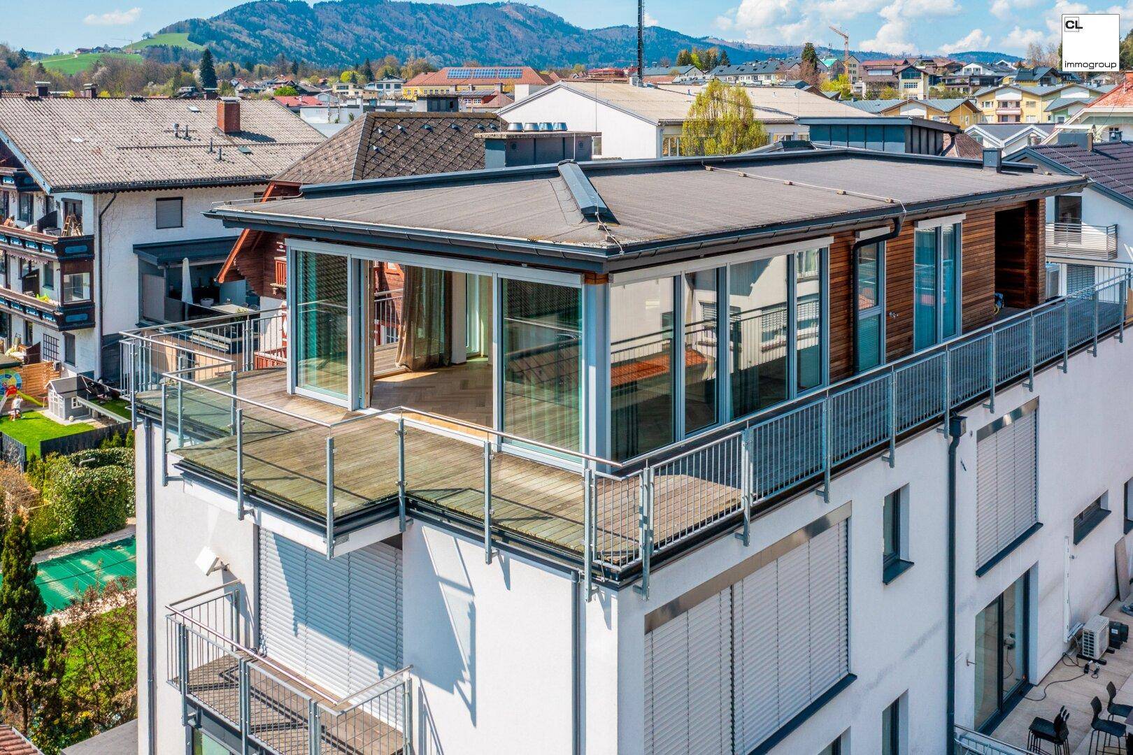 Moderne Architektur mit großzügigen Terrassenbereichen und weitem Blick auf die Stadt und Berge.