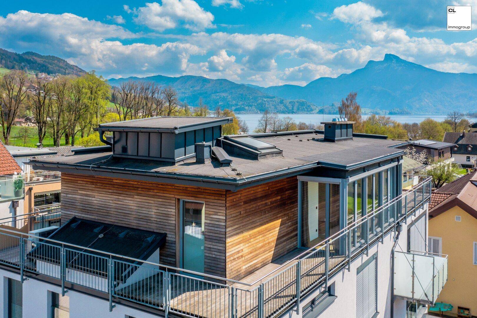 Dachgeschosswohnung mit großer Dachterrasse und Panoramablick auf die umliegende Landschaft und den See.
