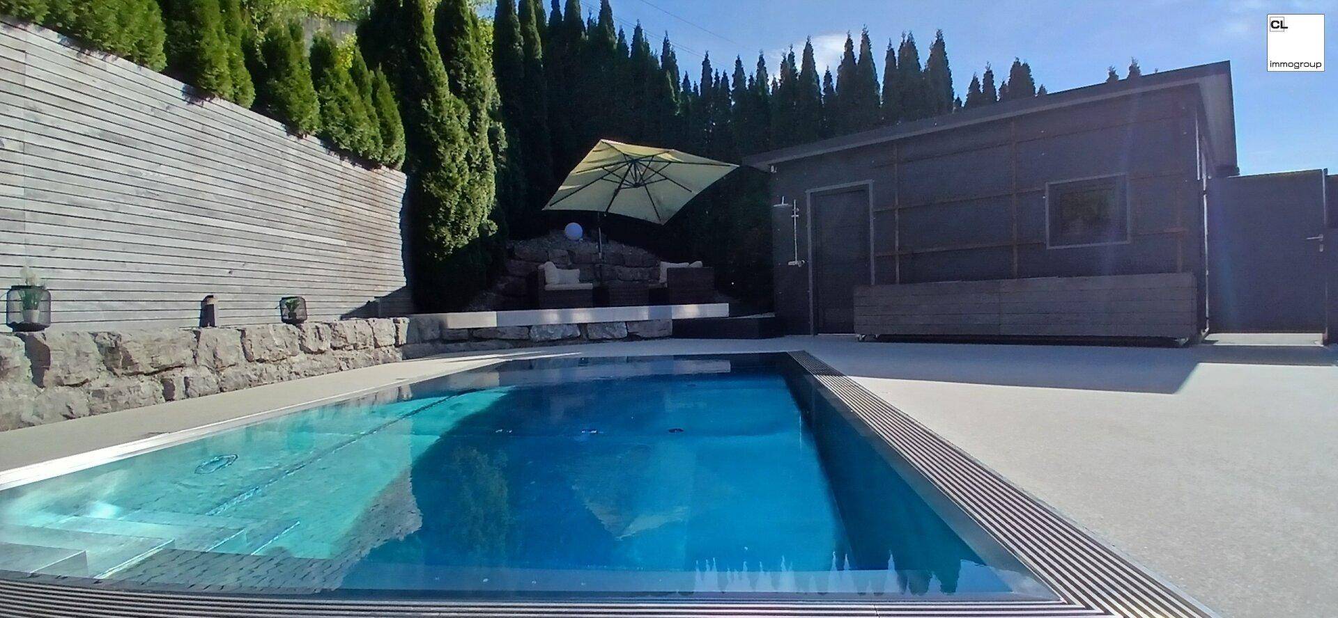 Weitläufiger Poolbereich mit modernem Gartenhaus und umgebender Hecke.