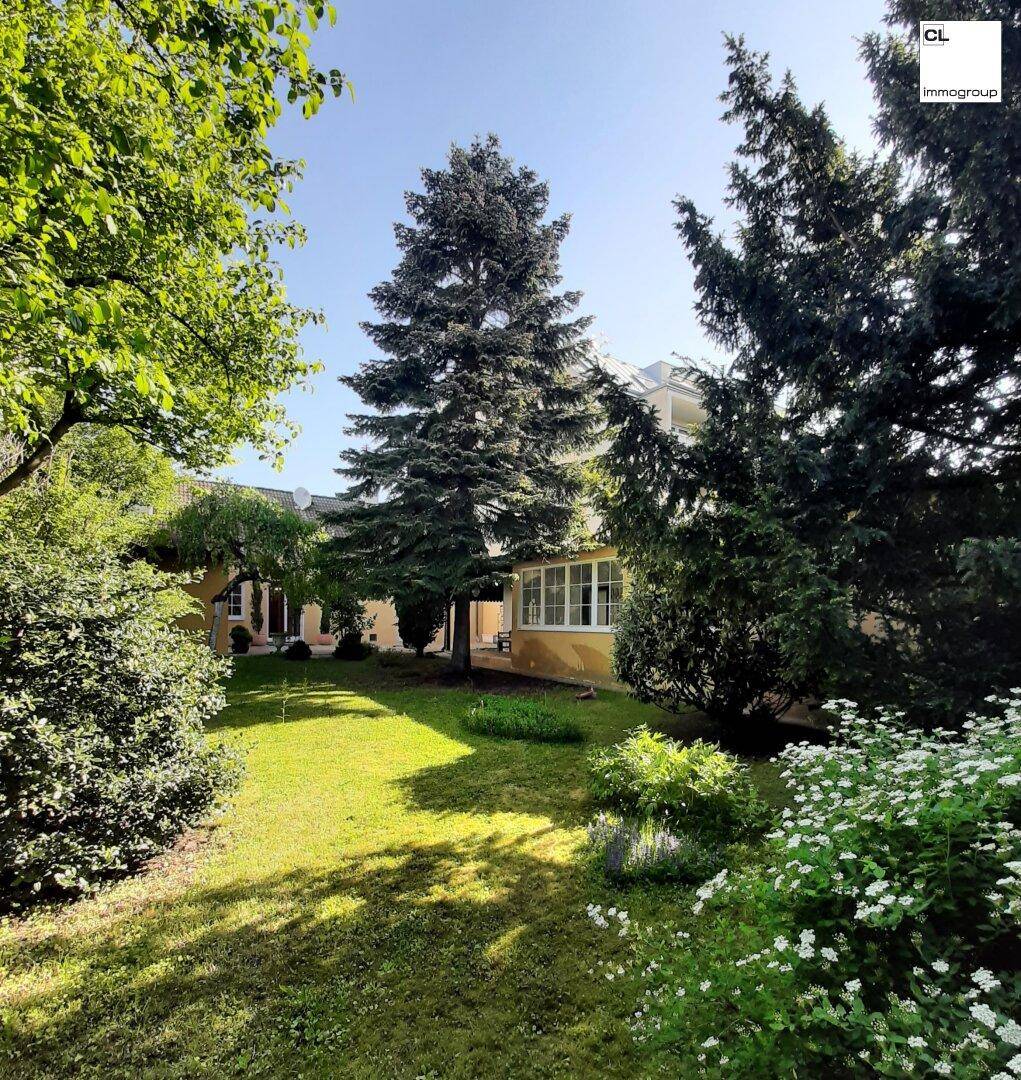 Großer, gepflegter Garten mit hohen Bäumen und Sträuchern, der zum Haus gehört.