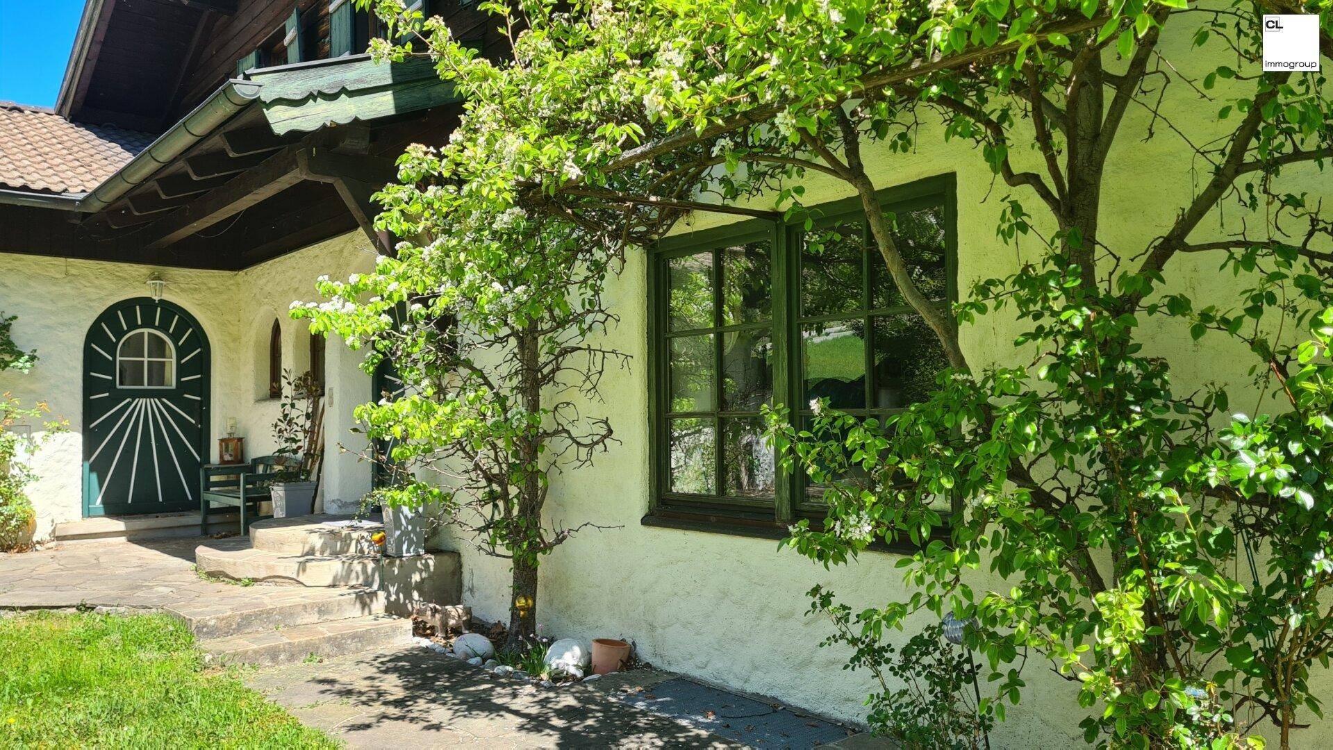 Detailansicht der Hausfassade mit grünen Fensterläden und bewachsenen Wänden.