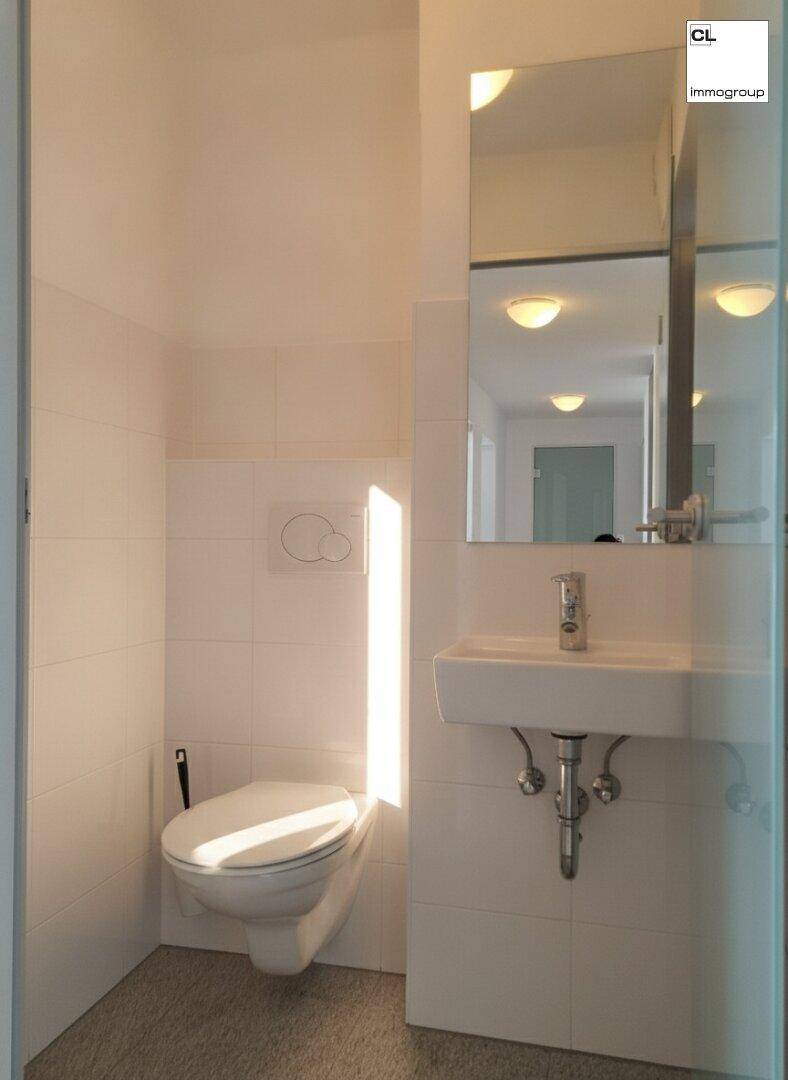 Helles Gäste-WC mit wandhängender Toilette, Einzelwaschbecken und einem Spiegel über dem Waschtisch.
