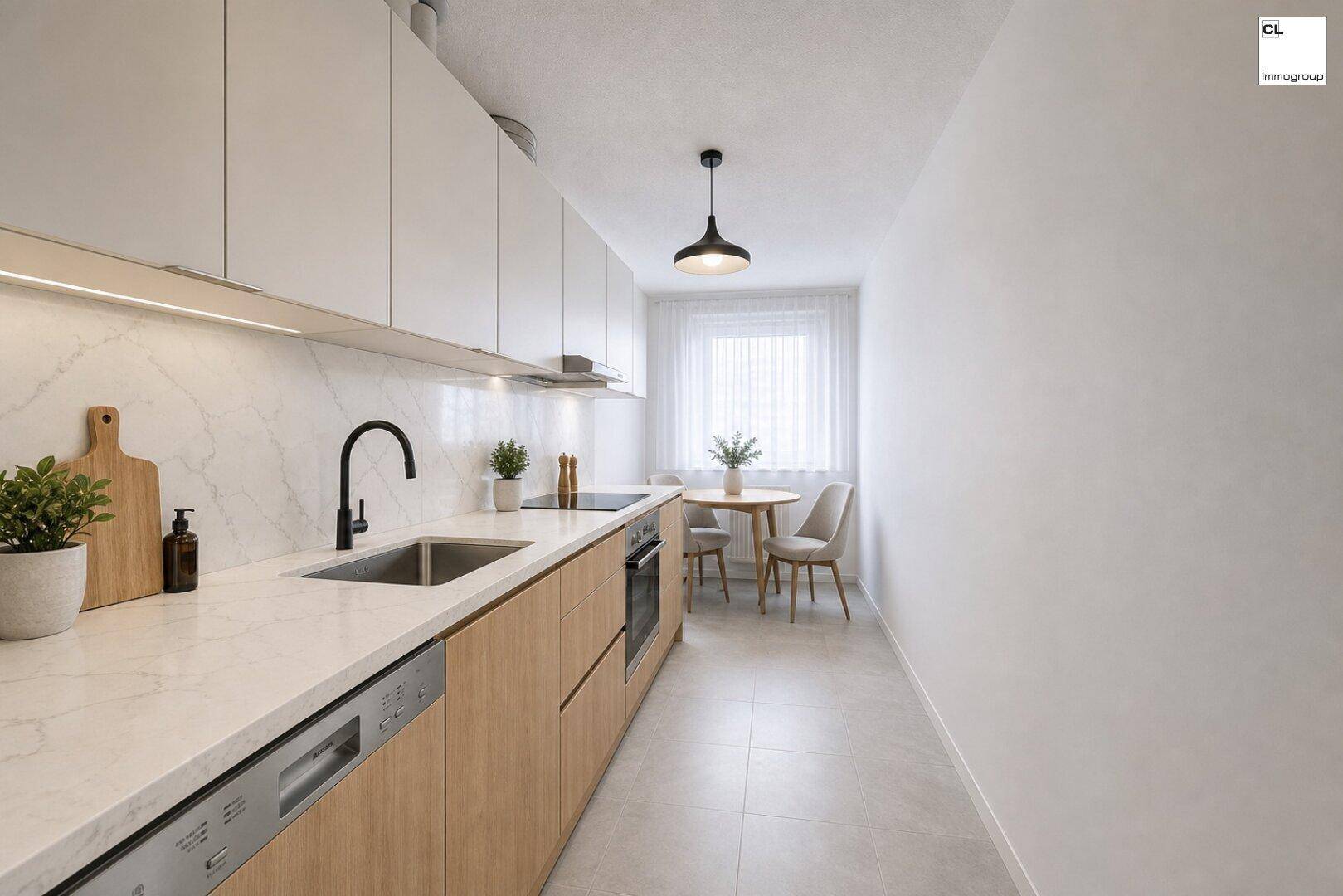 Moderne Küche mit weißen und holzfarbenen Schränken, heller Arbeitsplatte und kleinem Essbereich am Fenster.