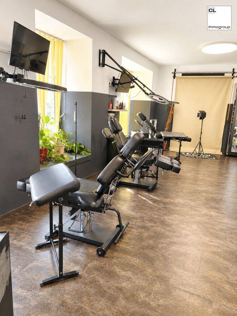 Heller Arbeitsbereich in einem Tattoo-Studio mit mehreren Liegen und professioneller Beleuchtung, bereit für Kunden.