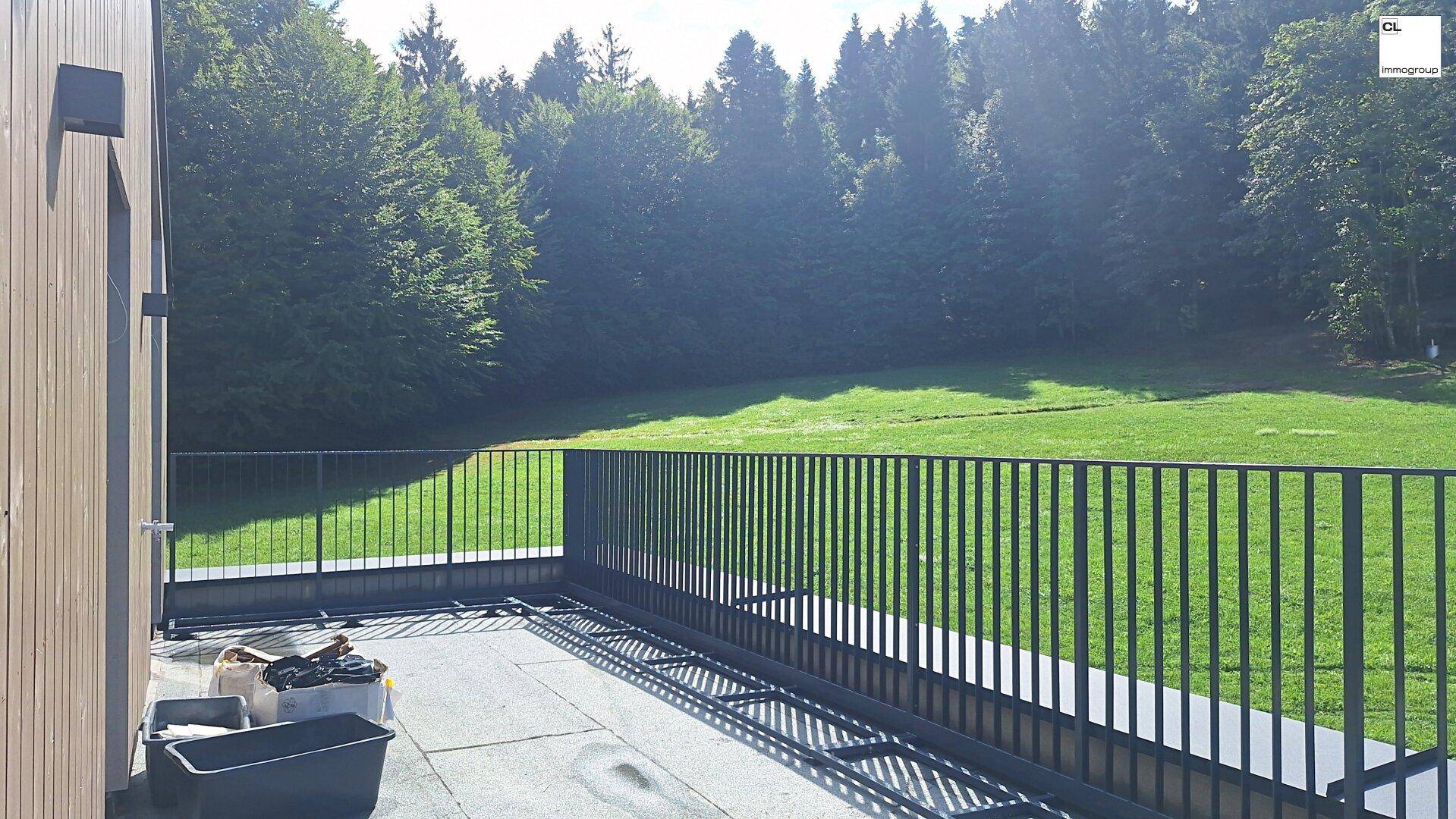 Geräumige Terrasse im Bau mit Blick auf die umliegende Natur und viel Grün.