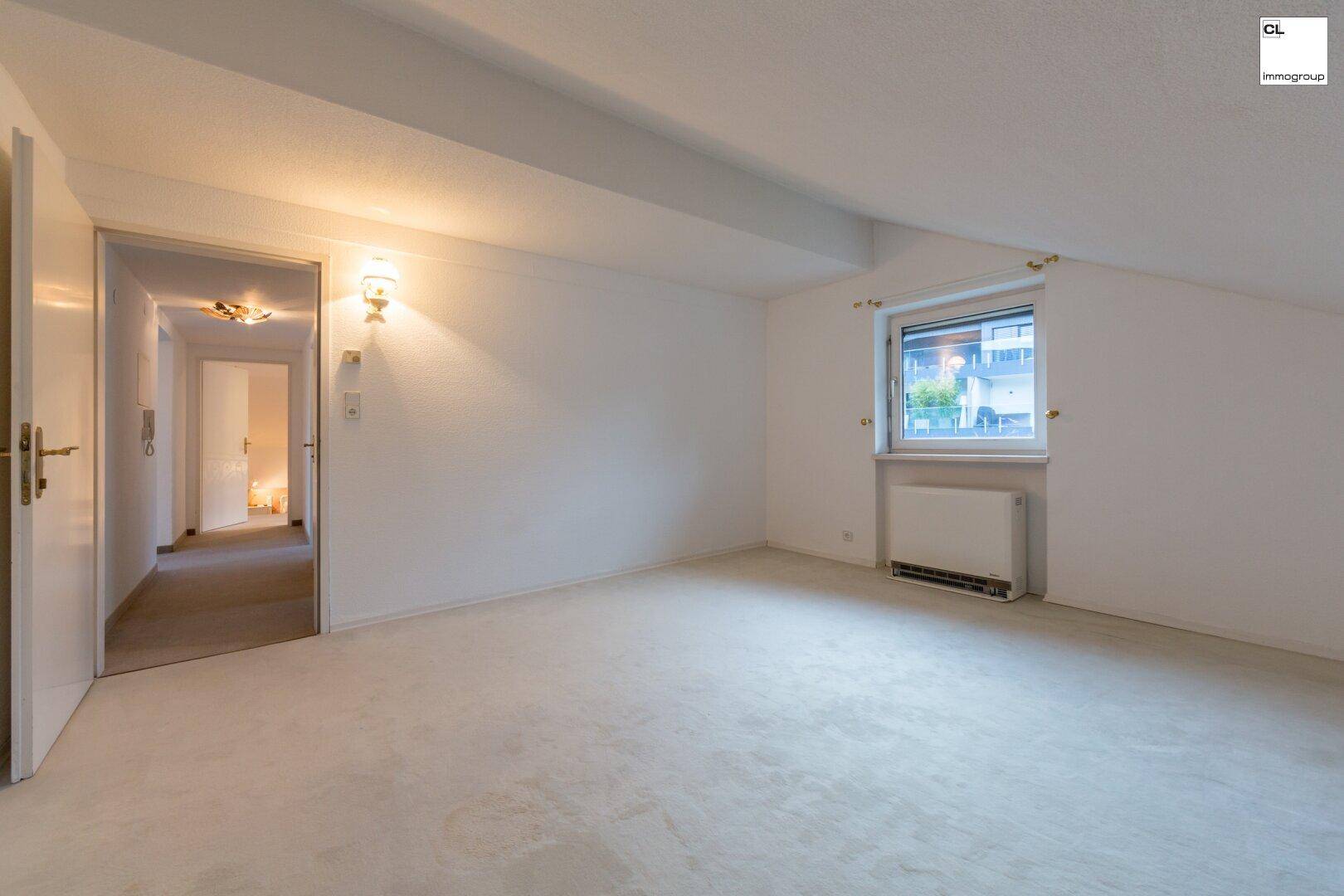 Helles Schlafzimmer mit Teppichboden und Fenster, bereit zur individuellen Gestaltung im Dachgeschoss.