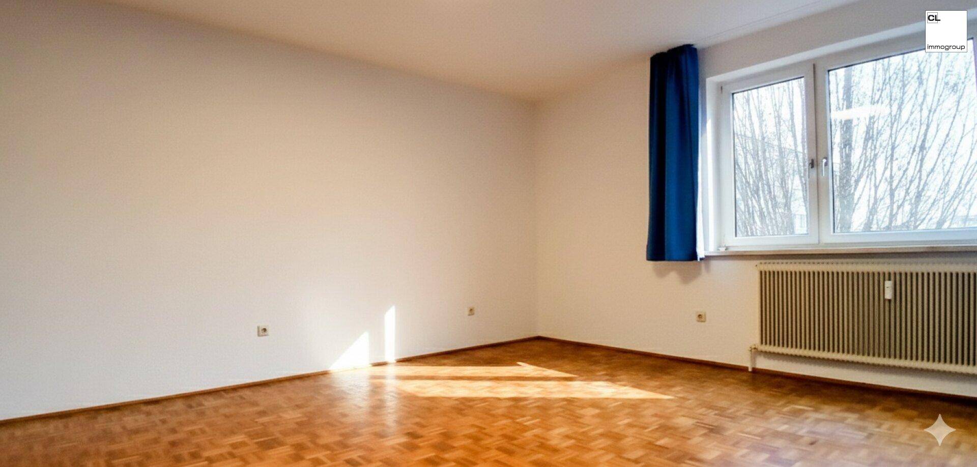 Heller, leerer Raum mit Fischgrätparkettboden und einem Fenster, das viel Tageslicht hereinlässt.