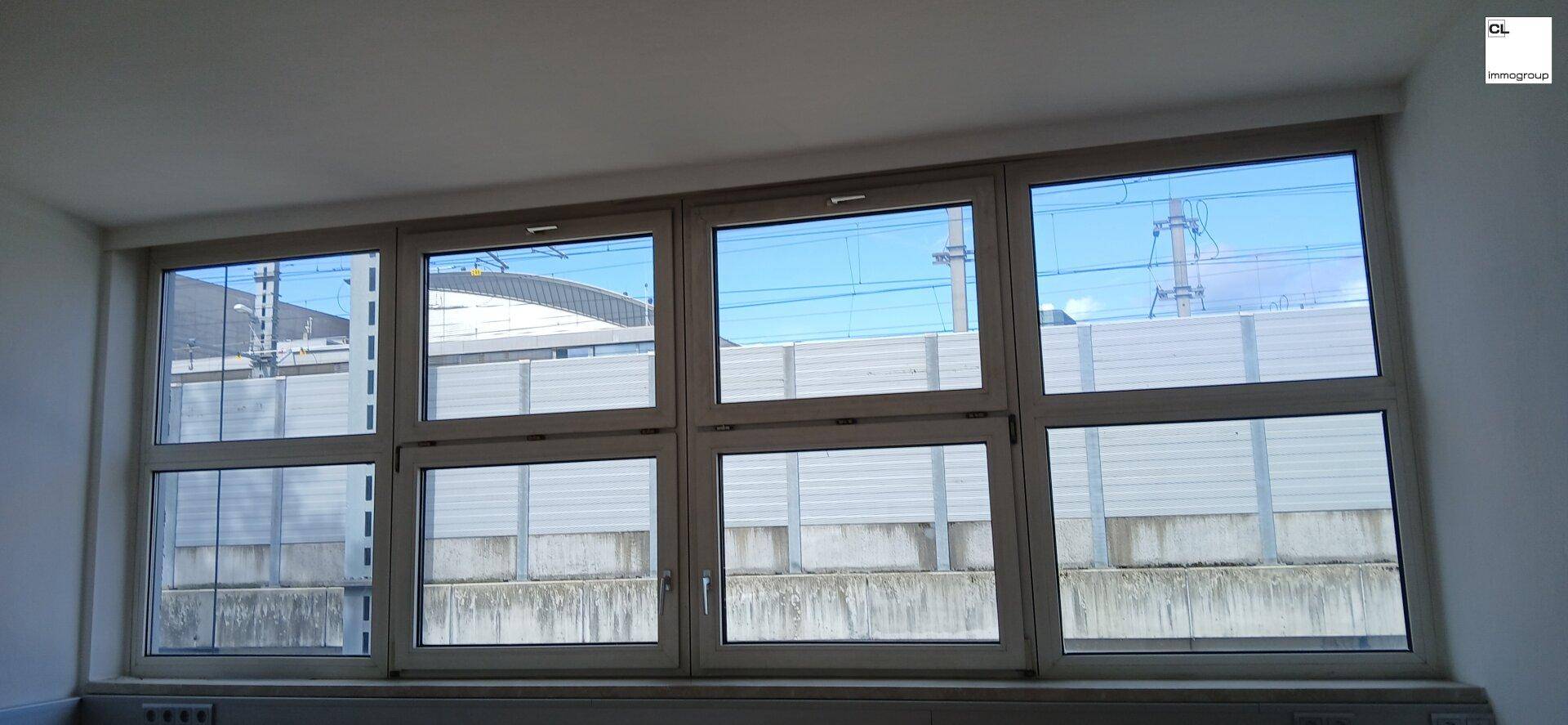 Fenster mit Blick auf die Bahngleise und die Lärmschutzwand, bietet eine weite Aussicht.
