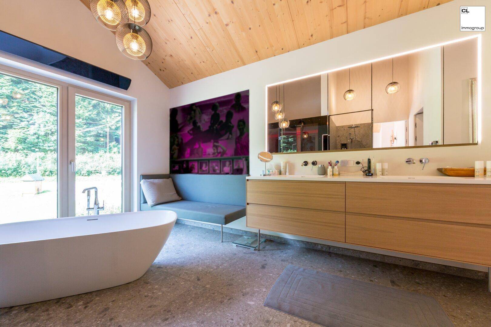 Geräumiges Badezimmer mit Doppelwaschbecken, großer Spiegelfläche und freistehender Badewanne.